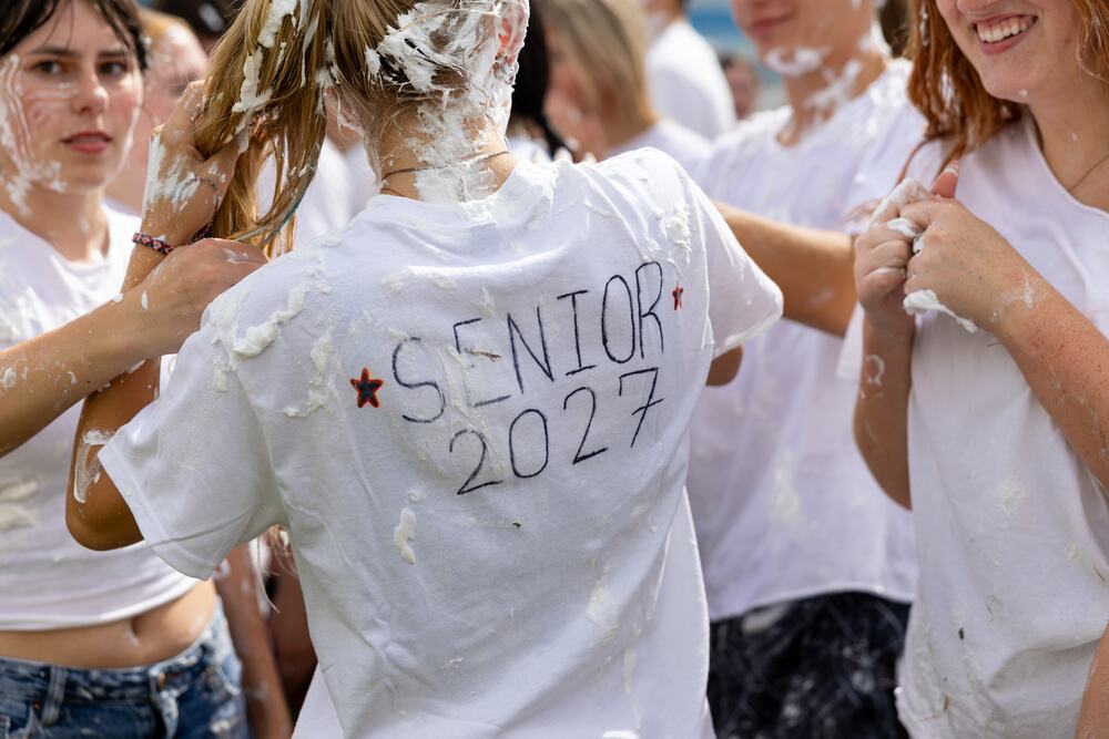 The back of a white T-shirt with "Senior 2027" written across it in marker, covered in shaving cream.