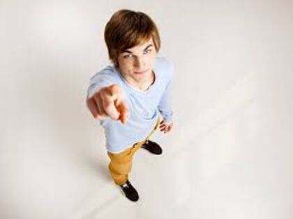 A senior photographed from high above, pointing up at the camera